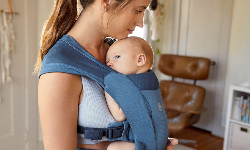 Mum wearing a newborn baby in an Ergobaby Embrace baby carrier