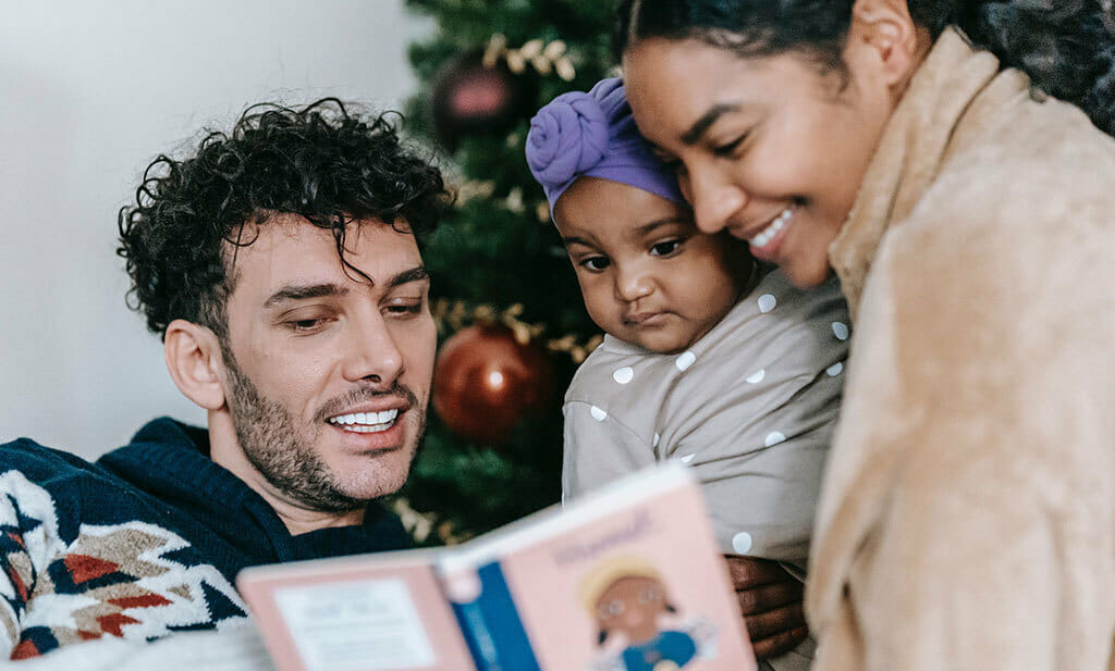 Baby Sleep Guide Christmas Edition, family reading book by Christmas tree