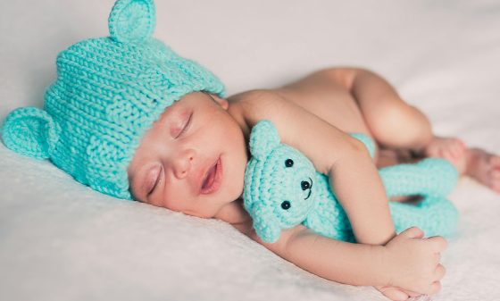 Baby lying with teddy bear